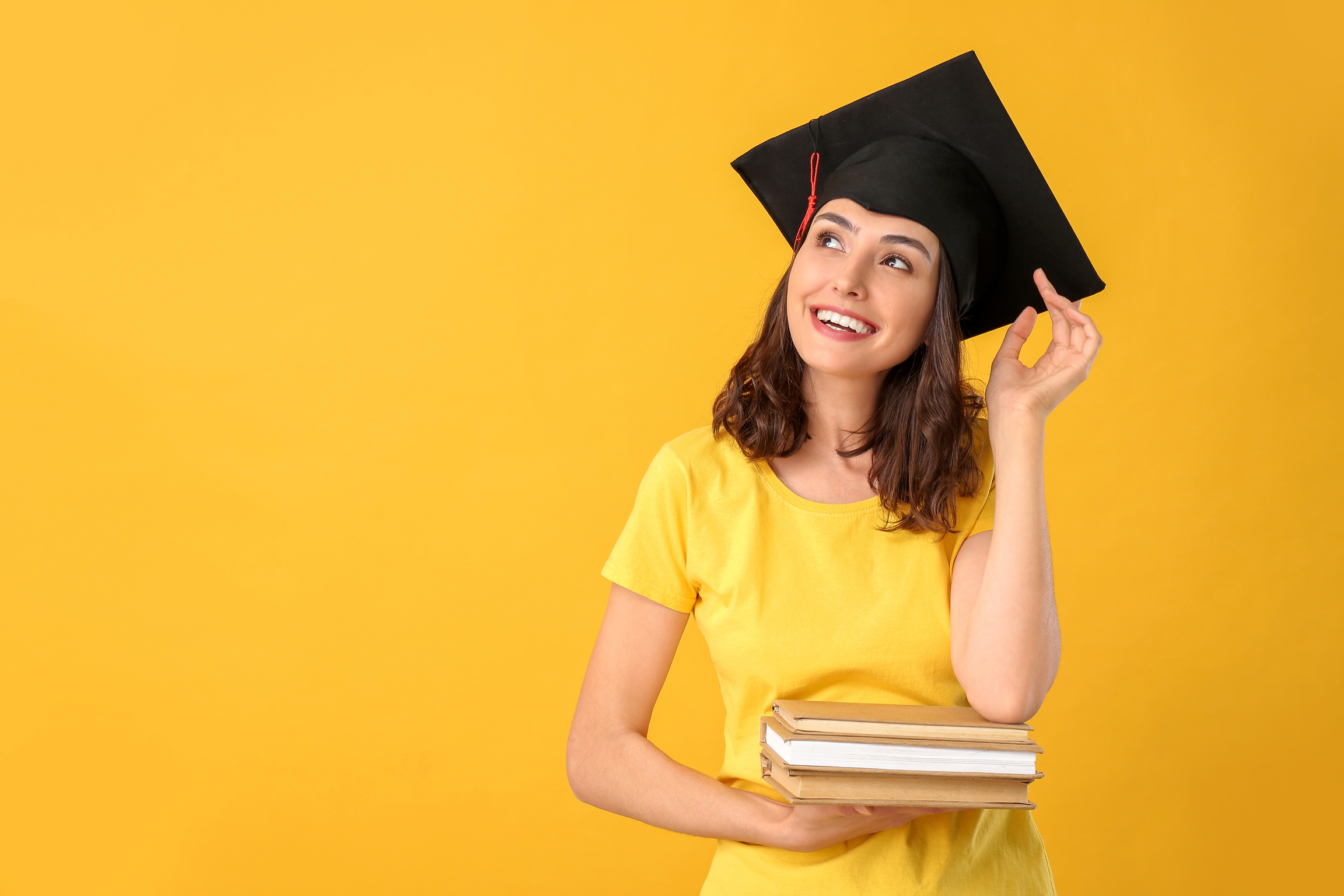 Female Graduating Student with Books on Color Background